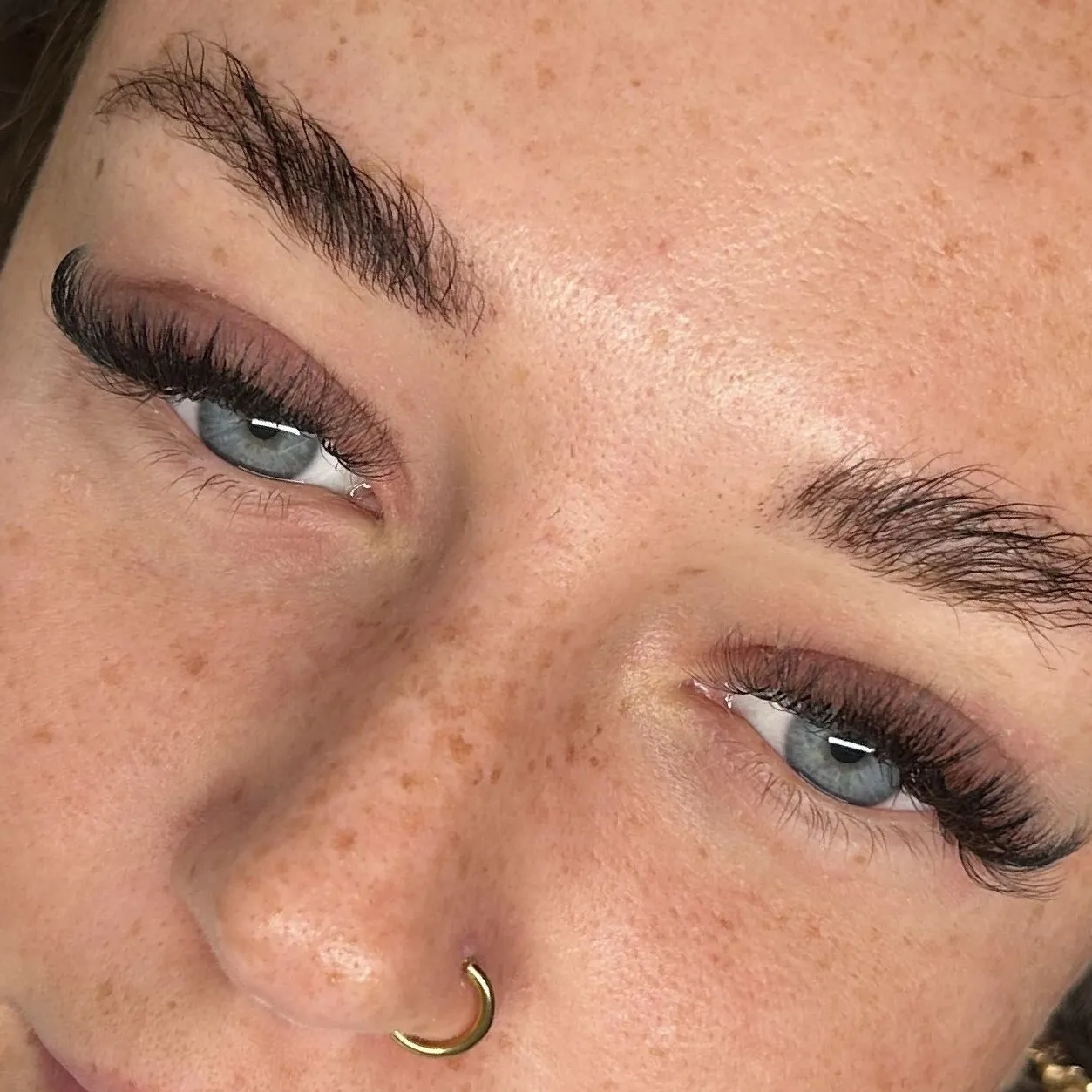 A soft, wispy hybrid lash set on blue eyes