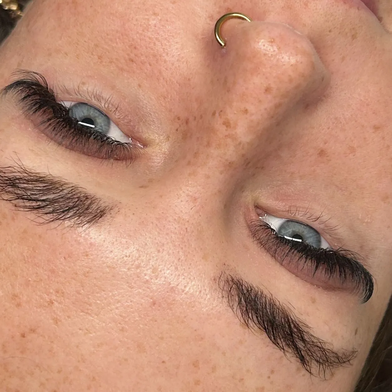 Soft hybrid lashes on a freckled client